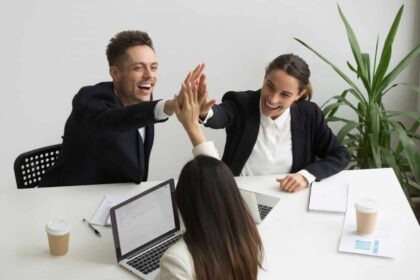 excited millennial office team giving high five together teambuilding concept 1280x853 1