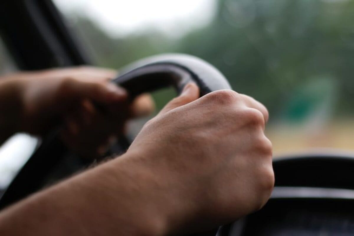 male hand holding caracteristic Autos Rodando al volante