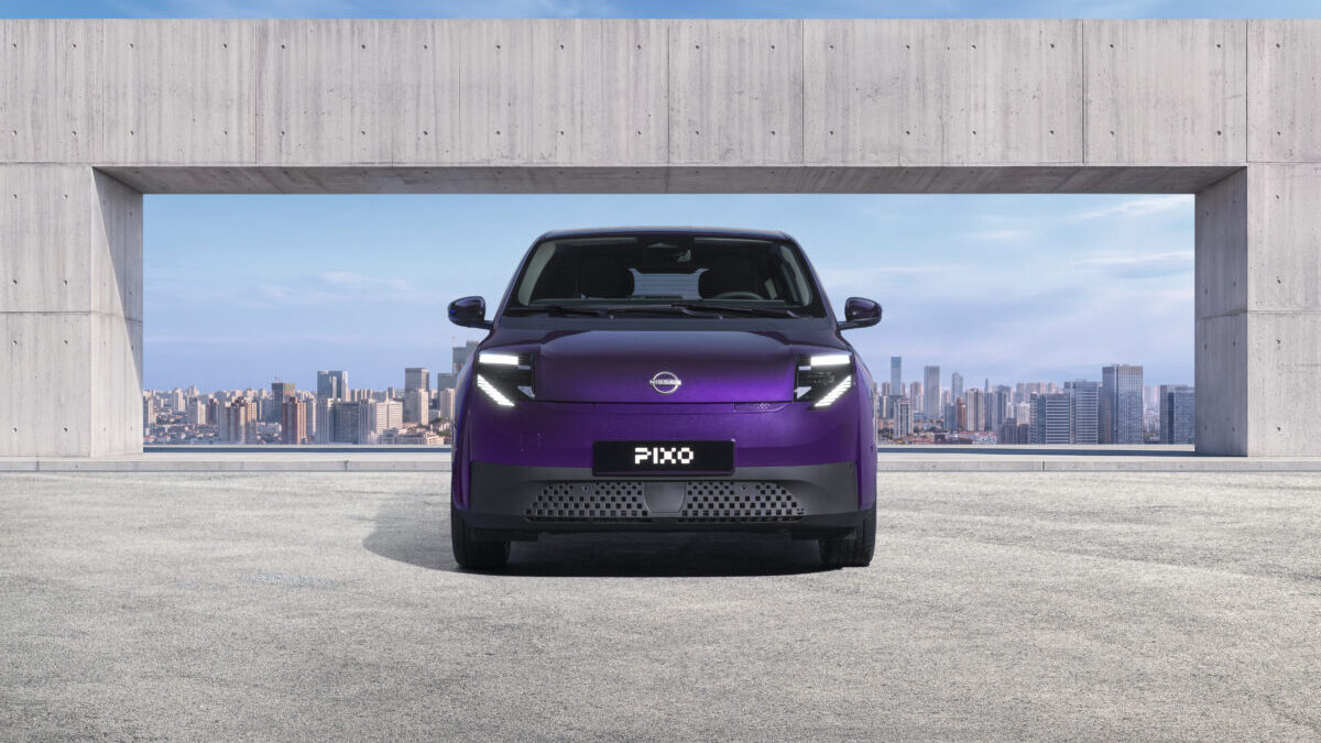 Nissan Pixo: el pequeño eléctrico que llega con 259 km de autonomia y una sorpresa enorme 3 Photograph showcasing a purple Nissan Pixo concept car parked before a concrete architectural opening with a city skyline beyond. Front view highlights illuminated angular headlights, closed grille, PIXO plate, sleek compact design, and blue sky backdrop.